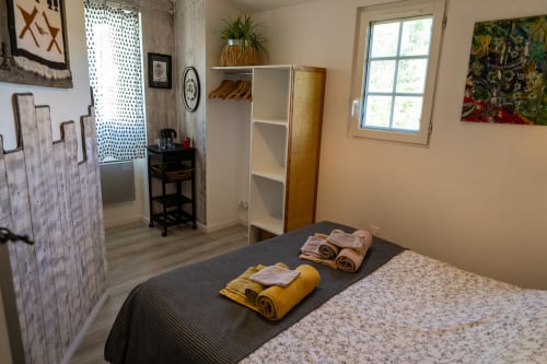 Chambre d'hôtes Socoa à Espelette : un hébergement lumineux avec grand lit, coin rangement et plateau de courtoisie pour un séjour serein au Pays Basque.