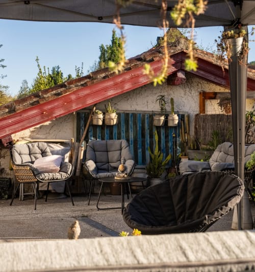 Coin lounge extérieur sous le toit du Moulin de Pascale à Espelette, ambiance zen et détente au cœur du village.