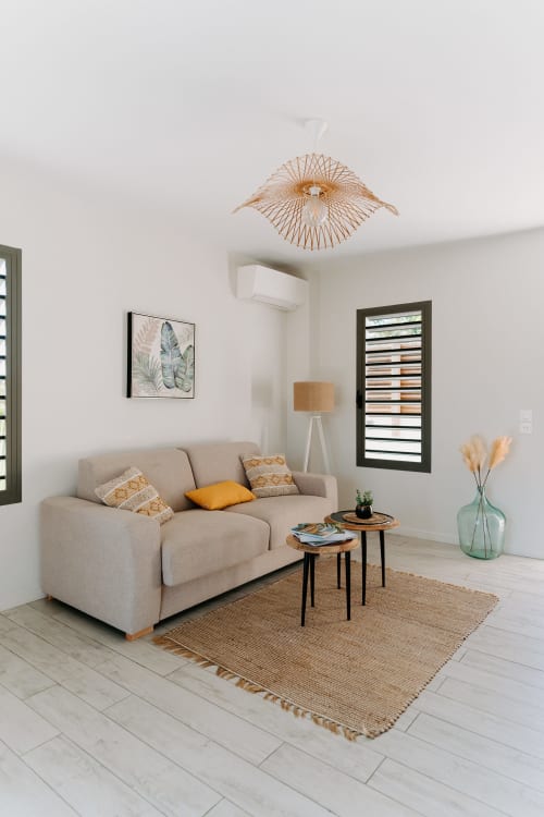 Salon moderne à l'Habitation I'SEO à Sainte-Anne avec canapé beige, tapis tissé et décoration naturelle