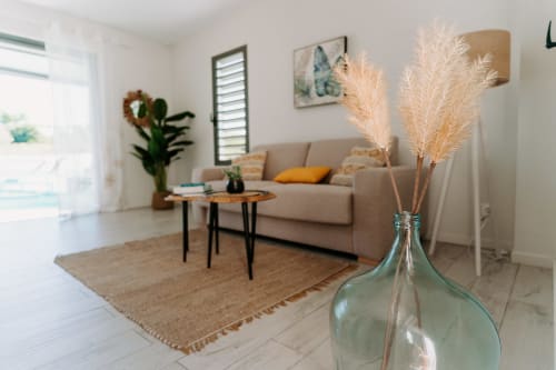 Salon moderne et lumineux à Habitation I'SEO avec canapé beige, décoration pampa et lumière naturelle