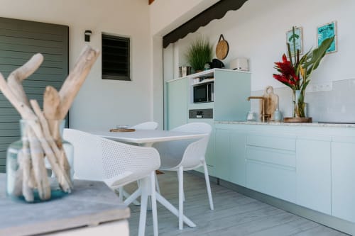 Cuisine moderne menthe à l'Habitation l'SEO, Sainte-Anne avec chaises blanches, fleurs en pot et décor côtier