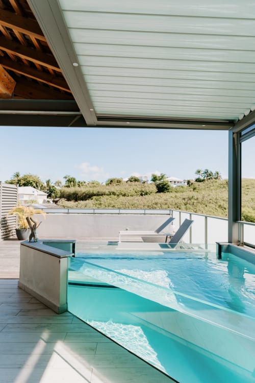 Terrasse piscine de luxe Habitation I'SEO à Sainte-Anne, Guadeloupe avec eau turquoise, transats et vues tropicales