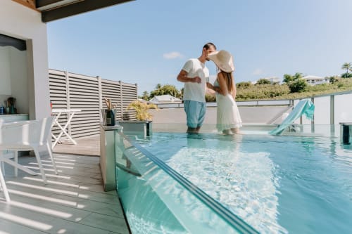 Couple profitant de la piscine sur le toit de l'hôtel Habitation l'SEO à Sainte-Anne, Guadeloupe avec vue sur l'océan
