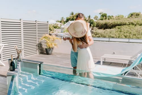 Couple enjoying poolside at Habitation l'SEO in Sainte-Anne, Guadeloupe with tropical views