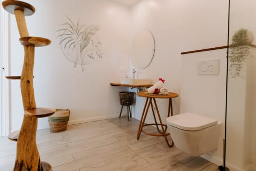 Salle de bain moderne à l'Habitation I'SEO à Sainte-Anne avec vasque en bois, miroir rond et décoration minimaliste