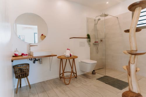 Salle de bain moderne à l'Habitation I'SEO à Sainte-Anne avec vasque en bois, miroir rond, douche italienne et décoration en bois