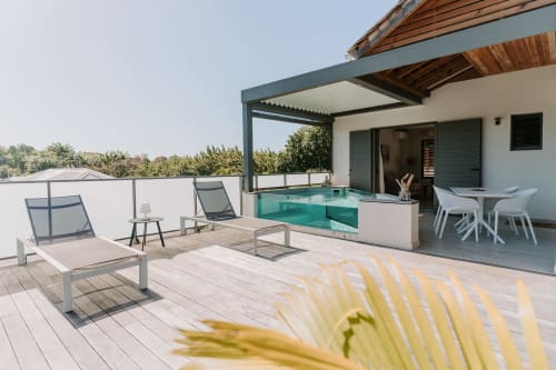 Terrasse moderne avec transats, piscine turquoise et espace repas à l'Habitation I'SEO, Sainte-Anne, Guadeloupe