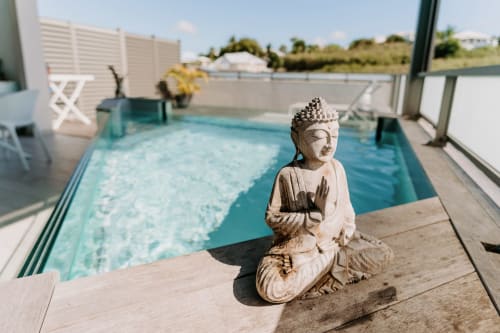 Buddha statue on deck beside turquoise tiny pool at Habitation I'SEO, Sainte-Anne, Guadeloupe