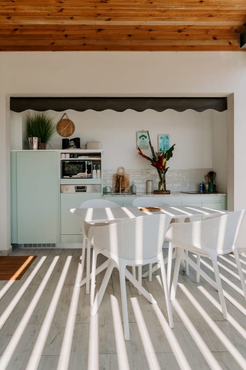 Cuisine moderne et coin repas du studio Habitation I'SEO avec chaises blanches, kitchenette équipée et lumière naturelle