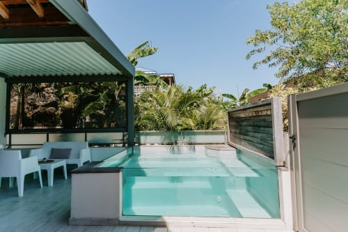 Studio moderne avec piscine turquoise privée, salon extérieur et jardin tropical luxuriant à Habitation I'SEO, Sainte-Anne