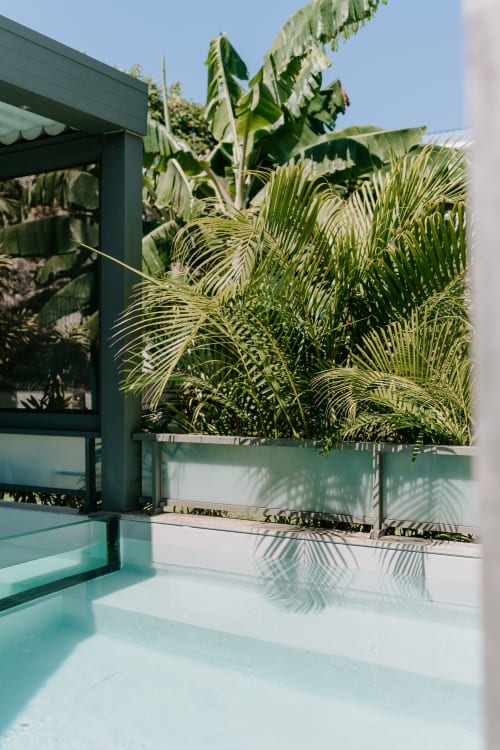 Terrasse de piscine tropical moderne à Habitation l'SEO à Sainte-Anne avec eau turquoise, palmiers luxuriants et architecture verdoyante