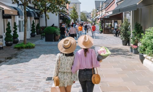 Two women walking through an upscale shopping village near Disneyland Paris in Serris, France