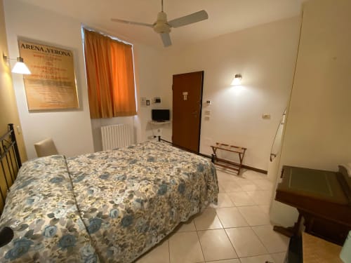 Camera spaziosa ad Alloggio Le Casette a Verona con letto, TV, ventilatore a soffitto e comfort moderni