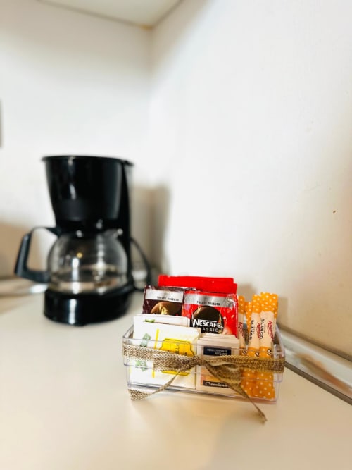 Cafetera y canasta de bienvenida con sobres de Nescafé en apartamento de Mérida