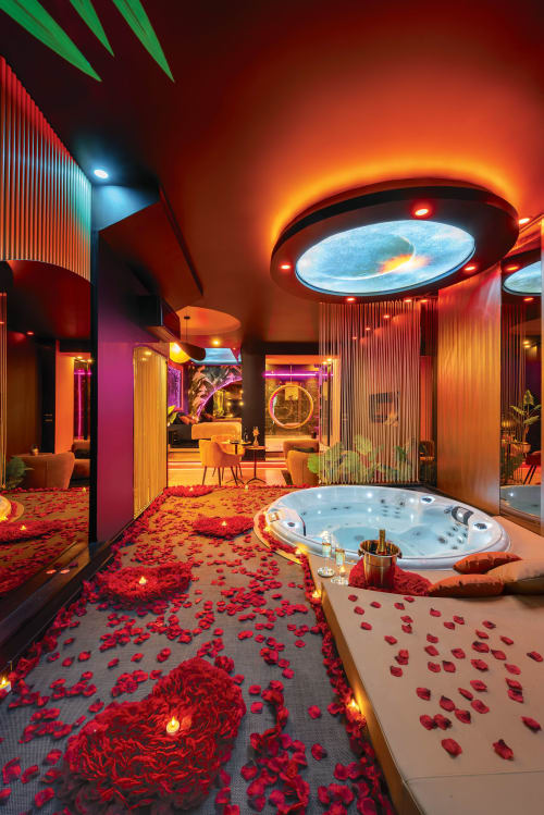 Suite spa privée luxueuse à L'Insolite Toulouse avec jacuzzi, pétales de roses rouges, éclairage ambiant et design futuriste en forme d'OVNI