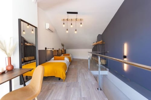 Dormitorio moderno en J&A Apartments en Terrassa con ropa de cama amarilla, iluminación contemporánea y decoración elegante