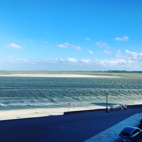 Vue sur la plage du Crotoy depuis le Gite Les Mouettes Blessées, avec la mer, plage de sable et paysage côtier sous ciel bleu