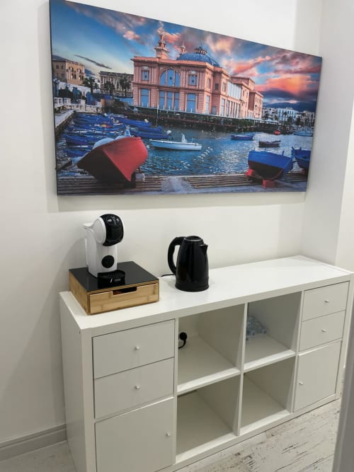 Camera d'hotel moderna a Bari con mobile bianco, macchina per caffè e opera d'arte con veduta del porto marittimo