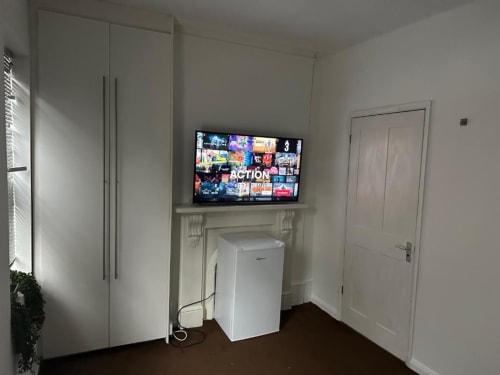 Cupboard storage and fridge in room