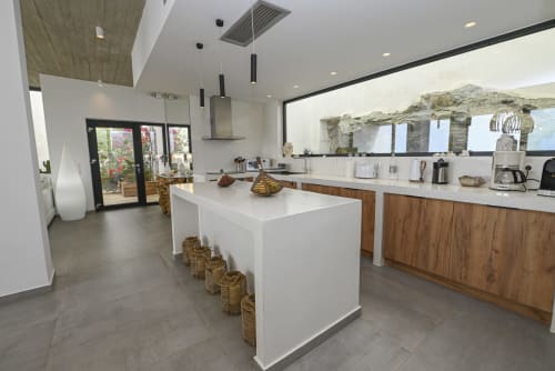Equipped kitchen and entrance to the villa for rent: panoramic windows overlooking the gardens, the sea and the beautiful rocks