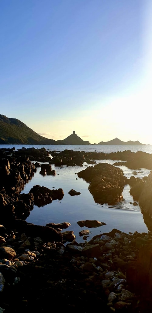 Plage rocheuse côtière au coucher de soleil avec pics montagneux caractéristiques de l'Ile des Sanguinaires, près de VillaSerenita, Ajaccio, Corse