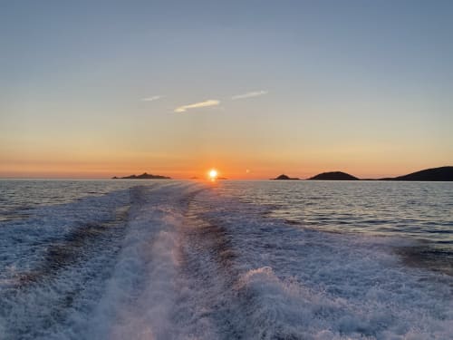 Coucher de soleil sur les eaux méditerranéennes près de VillaSerenita, Ajaccio, Corse, avec vagues, îles des Sanguinaires et ciel doré