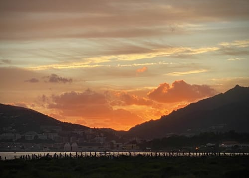 Magnifique coucher de soleil près de VillaSerenita, Ajaccio, Corse avec des nuages dorés, montagnes et vue sur la baie d'ajaccio