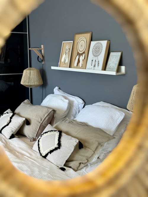 Chambre la VillaSerenita à Ajaccio, Corse, France avec mur d'accent gris, étagère blanche avec art attrape-rêves, literie beige et lampes tissées.