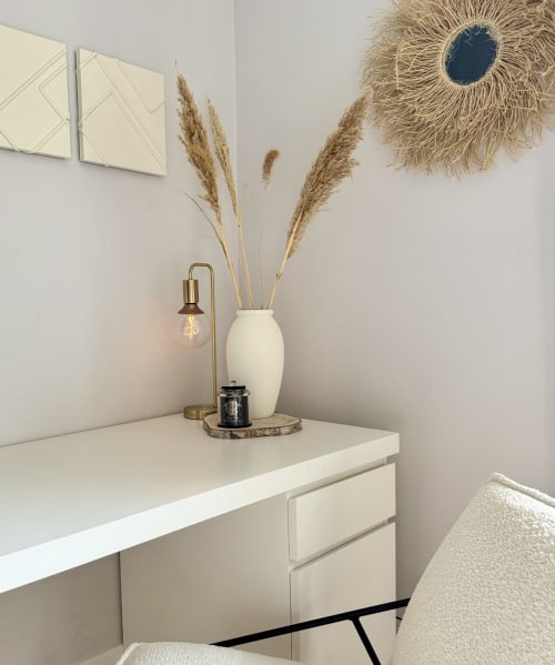 Bureau de chambre 2 de la VillaSerenita à Ajaccio, Corse, France avec bureau crème, arrangement de pampas, miroir décoratif et lampe en laiton