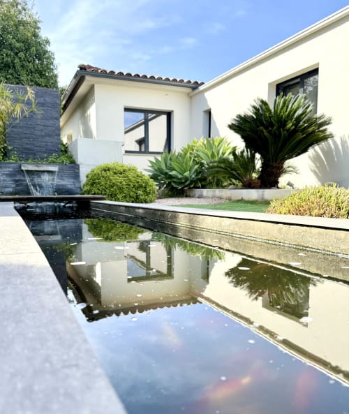 Bassin à poissons de la VillaSerenita à Ajaccio, Corse, France: architecture blanche épurée, piscine miroir et jardins tropicaux