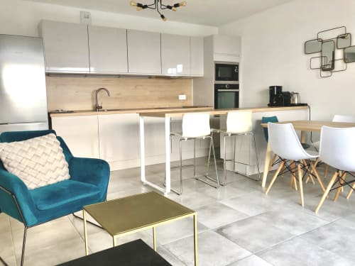 Cuisine - Salon du Frasso, appartement de la VillaSerenita à Porticcio, Corse, France propose un séjour moderne avec cuisine blanche, fauteuil bleu et salle à manger