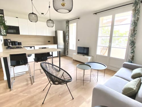 Cuisine ouverte et séjour contemporain des Oliviers, appartement de la VillaSerenita à Ajaccio, Corse, France avec luminaires suspendus, comptoirs bois
