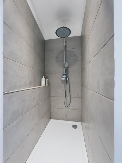 Salle de douche moderne à l'appartement SoleMare L'Ajax à Alata avec pomme de douche pluie, carrelage mural et sol en base blanche