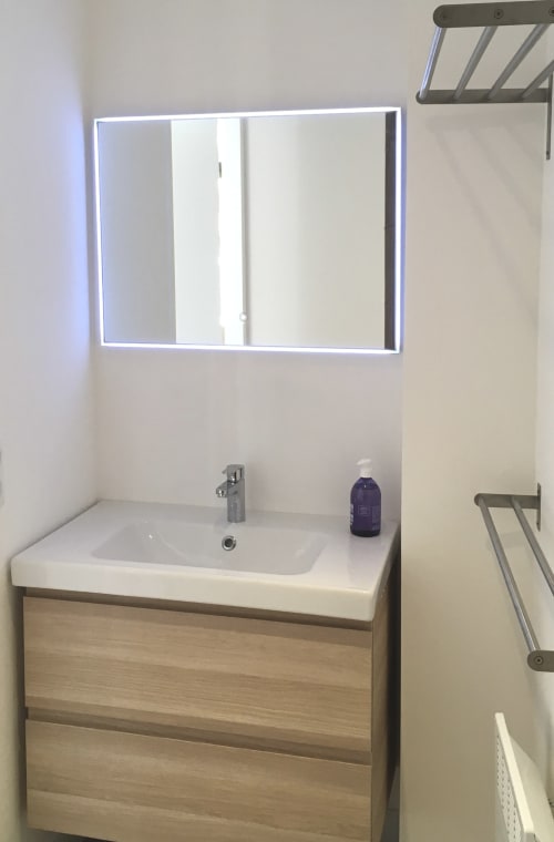 Vasque moderne avec meuble en bois et miroir LED - Appartement SoleMare à Alata