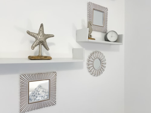 Décoration murale d'inspiration côtière chez CefalHome Roma avec figurine d'étoile de mer, miroirs décoratifs et styling d'étagère horloge