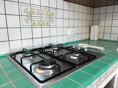 Cuisinière à gaz avec carrelage décoratif vert dans la cuisine CefalHome, Roma