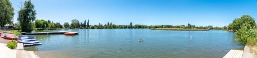 Scenic lake view at Le Fassardy bed & breakfast in Châteauroux, France with moored boats and tree-lined shores