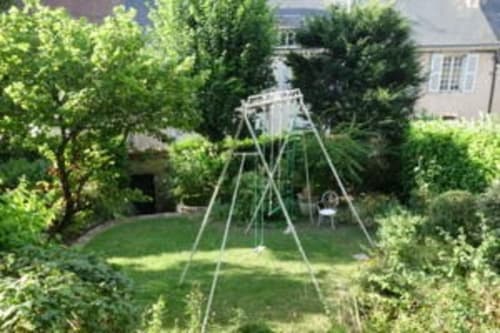 Lush garden with swing set at Le Fassardy bed & breakfast in Châteauroux, France