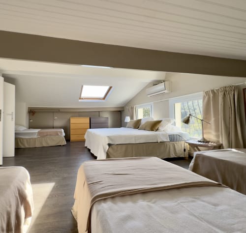Chambre spacieuse de à VillaSerenita à Alata avec plusieurs lits, puits de lumière et mobilier moderne