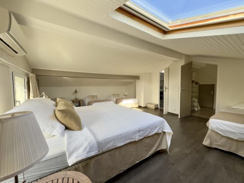 Chambre spacieuse sous les toits à à VillaSerenita Alata avec puits de lumière, literie blanche et équipements modernes