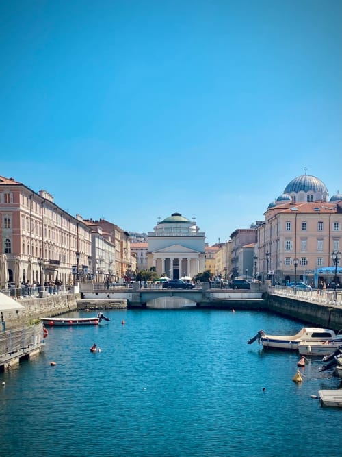 Lungomare di Trieste con architettura storica, canale blu e chiesa con cupola vicino all'hotel Saint Michel, Gorizia