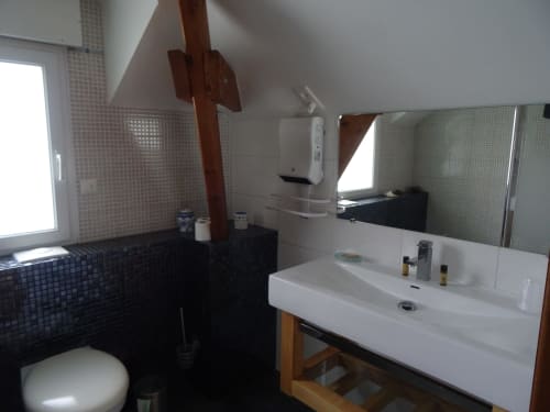 Salle de bain moderne au CafecouetBreizh BnB à Guipry-Messac avec lavabo blanc, miroir, carrelage noir et douche