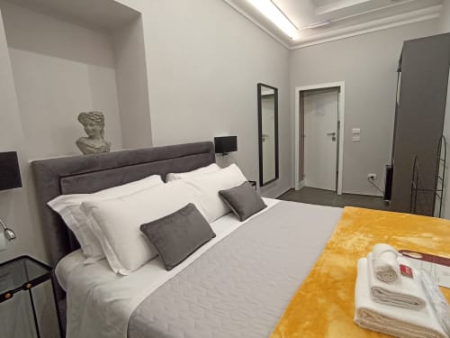 Modern bedroom at AD Trastevere Guest House in Rome with dark headboard, white linens, and contemporary decor