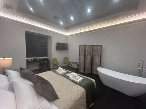 Luxury bedroom with freestanding bathtub at AD Trastevere Guest House Rome, featuring bed and modern amenities