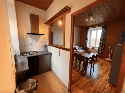 Cuisine et salle à manger chaleureuses du Restaurant du Port à Saint Pierre de Boeuf, avec poutres en bois et vue sur le lac