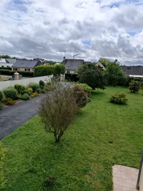 Jardin verdoyant aux arbustes matures de la maison d'hôtes CafecouetBreizh à Guipry-Messac, vue sur zone résidentielle