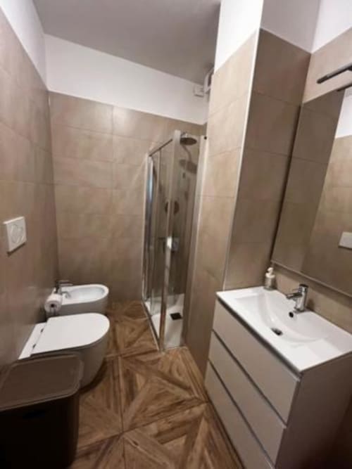 Moderni kupaonica u EmilBo' House s dvostrukim umivaonicima, bidetom, tuš kabinom i pločicama s drvenim uzorkom