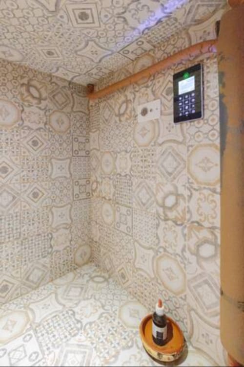 CasaRosada guestroom ceiling with patterned wallpaper, wooden beam, and security keypad in Vidracco