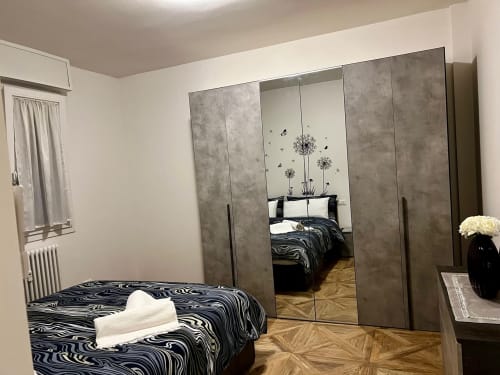 Moderna spavaća soba u EmilBo' House s ogledalom ormarićem, posteljinom sa zebra uzorkom, parketnom podlogom i pogledom na vrt u San