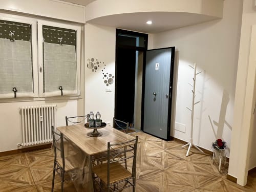 Moderna blagovaonica u EmilBo' House sa drvenim stolom, geometrijskom podlogom i suvremenim namještajem